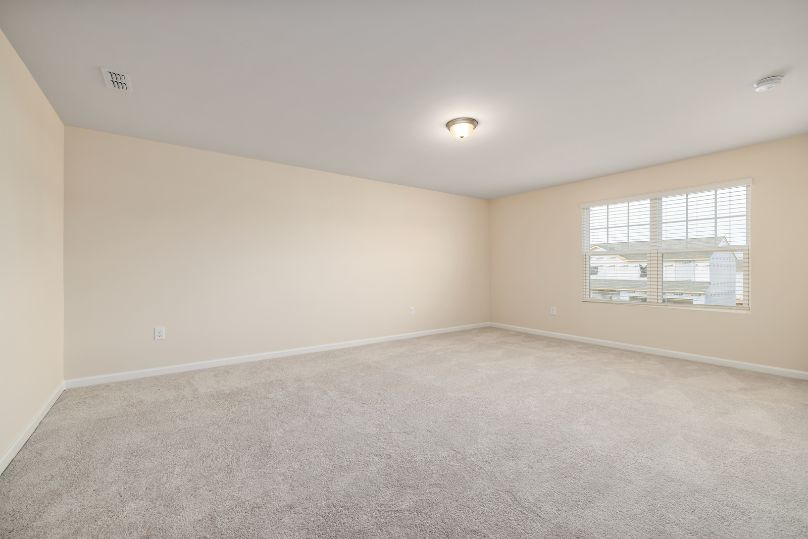 An Empty Room With Carpet and White Ceiling