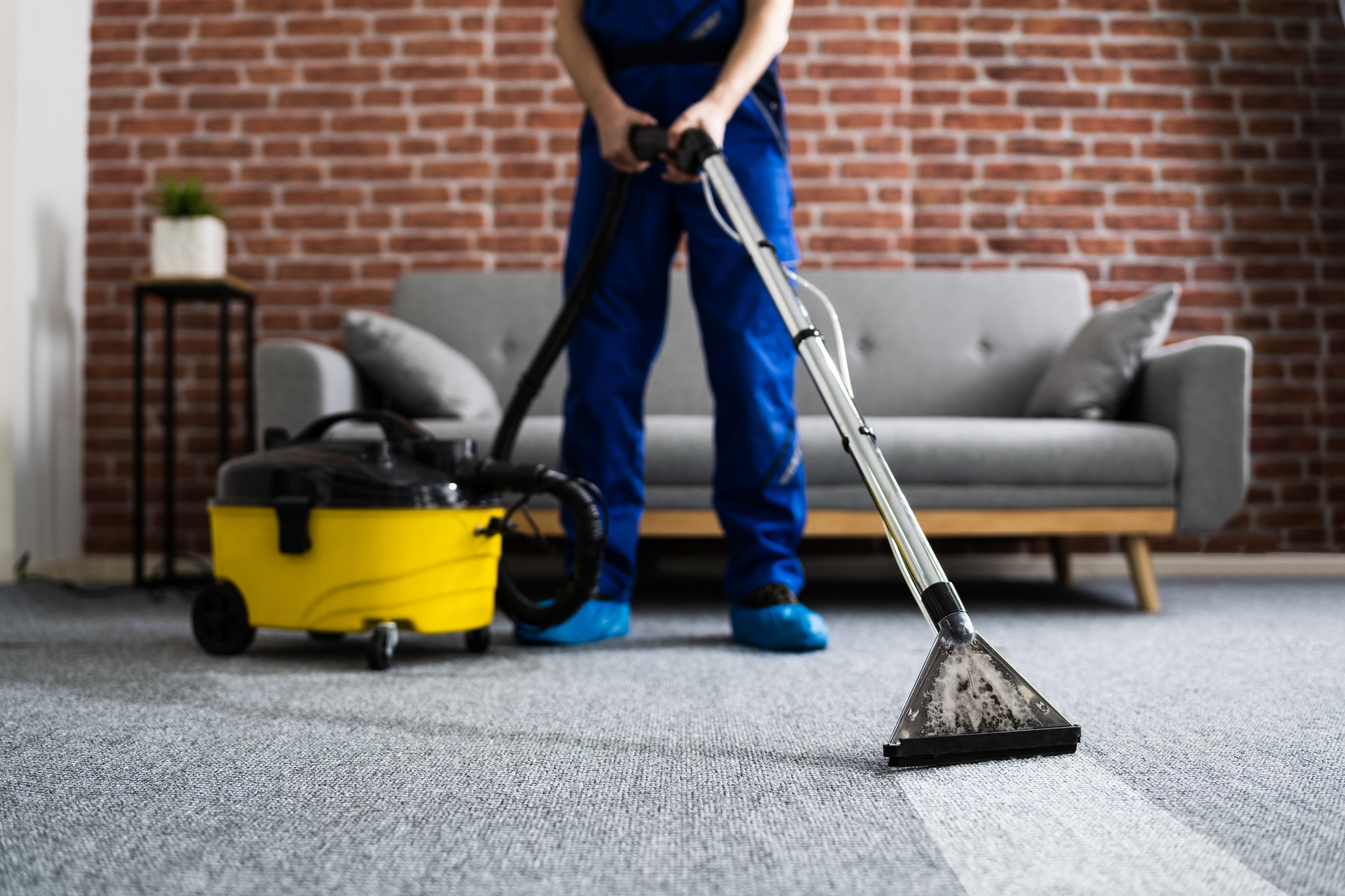 Janitor Cleaning Carpet With Vacuum Cleaner